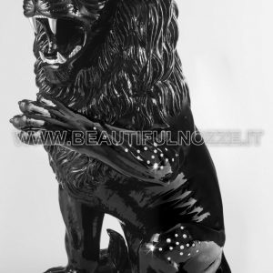 LEONE SEDUTO CON ZAMPA SX ALTA IN CERAMICA NERO CON OCCHI IN CRISTALLO SWAROVSKI